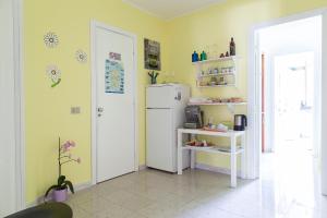 a kitchen with a white refrigerator in a room at B&b Margherita in Calasetta