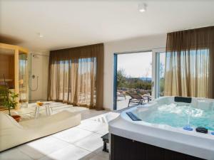 コロマチノにあるVilla A-R-T- by Interhomeの大きなバスルーム(バスタブ付)、リビングルームが備わります。