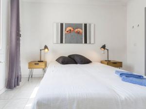 a bedroom with a large white bed with two lamps at Holiday Home Sunset by Interhome in Empuriabrava