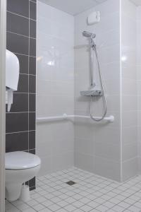 a bathroom with a shower and a toilet at Ekho Hotel Grenoble Nord Saint Egrève in Saint-Égrève