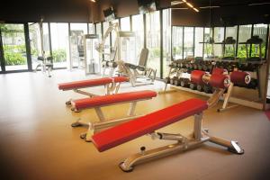 a gym with several red tread machines in it at Malaysia Johor Medini Studio in Nusajaya