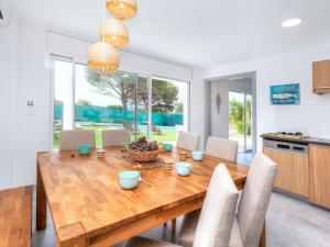 cocina y comedor con mesa de madera y sillas en Holiday Home Almendro by Interhome, en Santa Cristina d'Aro