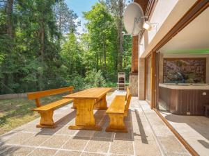 einem Picknicktisch aus Holz und Bänken auf einer Terrasse in der Unterkunft Chalet Lič by Interhome in Lič