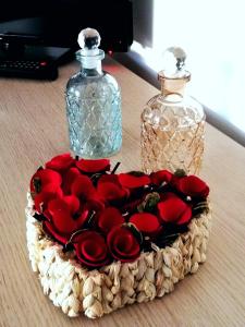 um ramo de rosas vermelhas e duas garrafas de vidro em le terme sotto casa 2 free em Rapolano Terme