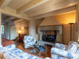 a living room with blue chairs and a fireplace at Holiday Home Il Podere by Interhome in Dicomano
