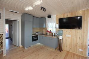 a kitchen with a flat screen tv on the wall at Karpu dīķis-Kempings Viesītes in Jaunmārupe