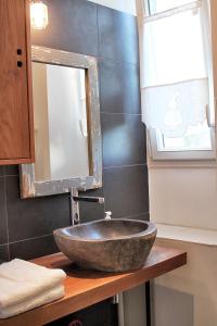 een badkamer met een stenen wastafel en een spiegel bij Apt 1 ch - Centre ville Vannes - Gare à pied - Parking in Vannes