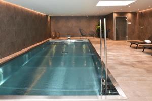 a swimming pool in a hotel lobby with chairs at Oceania Saint Malo in Saint Malo