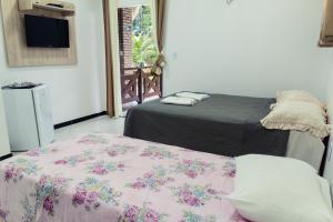 een slaapkamer met een bed met een deken erop bij Hotel Ibiapaba in Tianguá