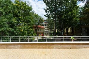 a bridge with trees and a building in the background at Dunav Apartment House in Sofia