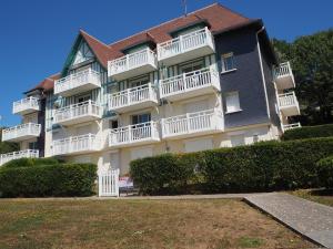 a large apartment building with white balconies and bushes at Cap Bleu in Blonville-sur-Mer