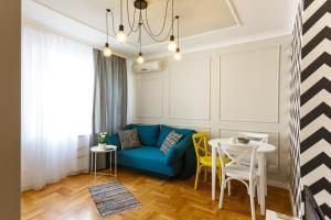 a living room with a blue couch and yellow chairs at CityResidence Aparthotel in Sofia