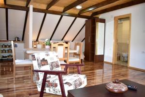 a living room with wooden ceilings and a table and chairs at Plitvice Panta Rei in Plitvička Jezera