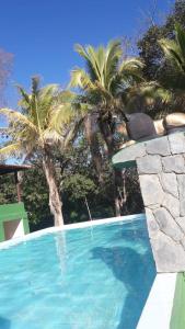 uma pessoa deitada à beira de uma piscina em Pousada Vila Cintra em Pirenópolis