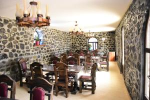 comedor con mesas, sillas y paredes de piedra en SİMSEK HOTEL&Restourant, en Qax