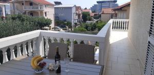 a bottle of wine and a banana on a balcony at Apartments Vahovec Vodice in Vodice