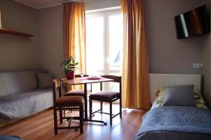 a living room with a table and chairs and a window at Pokoje gościnne U Jadzi in Chałupy