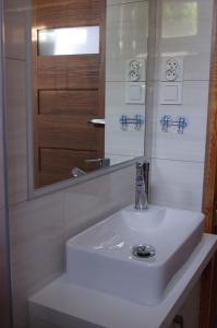a bathroom with a white sink and a mirror at Pokoje gościnne U Jadzi in Chałupy +14 photos