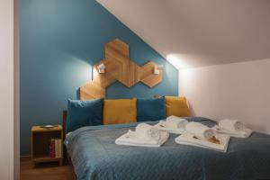 a bedroom with a blue bed with a cross on the wall at Apartamenty Szaron 250 m do kortów tenisowych i Bulwarów Wiślanych - Dream Apart in Ustroń