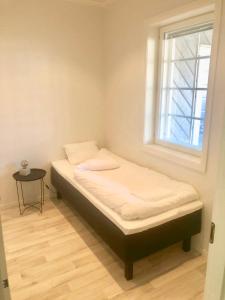 a small bed in a room with a window at Soda Home - Karlsro, 24 h check in in Närpiö