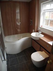a bathroom with a tub and a toilet and a sink at 22 Mill Road in Lincoln