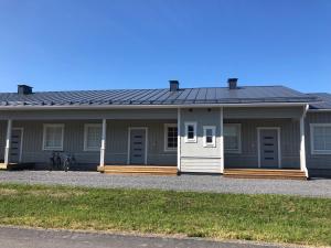 a gray house with a porch and a bike in front at Soda Home - Karlsro, 24 h check in in Närpiö