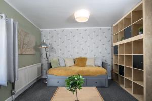 um pequeno quarto com uma cama e uma parede em Lighthouse of Stowmarket em Stowmarket