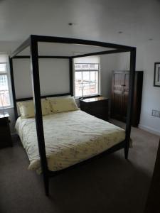 ein Schlafzimmer mit einem Himmelbett in einem Zimmer in der Unterkunft 22 Mill Road in Lincoln