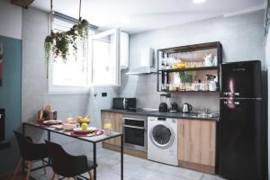 a kitchen with a washing machine and a table at River Side Olabeaga by homebilbao in Bilbao