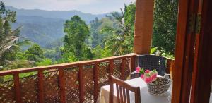 a balcony with a table and a basket of flowers at Ice Age Cottage in Ella