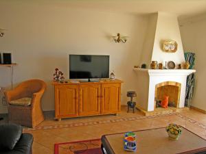 een woonkamer met een televisie en een open haard bij Casa da Praia para férias - Vila Pinheiro - Vivenda Johanna in Lagos