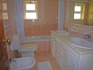 La salle de bains est pourvue de toilettes, d'un lavabo et d'une baignoire. dans l'établissement Casa da Praia para férias - Vila Pinheiro - Vivenda Johanna, à Lagos