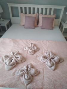 オシフィエンチムにあるApartament Julek klimatyzowanyのピンクの毛布にタオルをかけたベッド