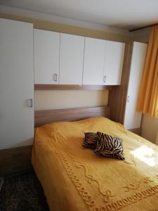 1 dormitorio con 1 cama con armarios blancos y almohada de cebra en APARTMA SONČEK en Ljubno