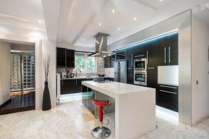 eine Küche mit einer weißen Theke und schwarzen Schränken in der Unterkunft Villa34 Family resort Renew, Relax, Revitalise & Spa Suite in Aghia Marina