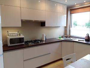 a kitchen with white cabinets and a microwave at Chillout in Stargard +17 photos