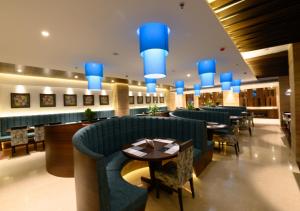 a restaurant with blue chairs and tables and blue lights at Novanta Jamshedpur in Jamshedpur
