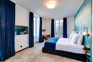 - une chambre avec un grand lit et des rideaux bleus dans l'établissement Le Palace De Menthon, à Menthon-Saint-Bernard
