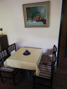 una mesa y sillas con una mesa y un cuadro en la pared en APARTMA SONČEK en Ljubno