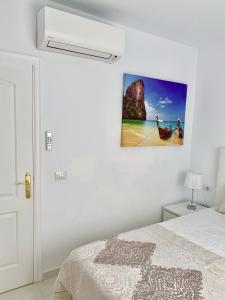 アデへにあるVilla Panoramic del Atlanticoのベッドルーム1室(ベッド1台付)が備わります。壁に絵が飾られています。