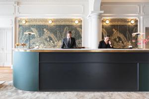 two men sitting at a bar in a room at Le Palace de Menthon in Menthon-Saint-Bernard