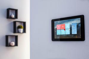 un televisor colgando de una pared con algunas fotos en Luxury Smart Apartments, en Szeged