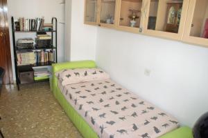 a green couch in a room with a book shelf at LOLA in Granada