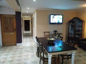 een woonkamer met een tafel en een tv aan de muur bij Liziwe's Guest House in Matroosfontein