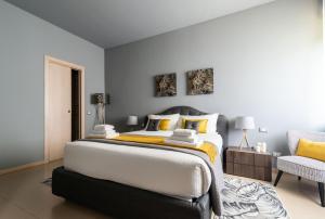 una camera con un grande letto e una sedia di Pagano Grancini 6 - City Life Luxury Apartment! Self Check-In a Milano