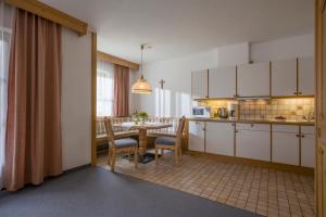 a kitchen and dining room with a table and chairs at Mehlerhof in Tux