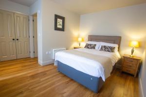 1 dormitorio con 1 cama grande y suelo de madera en The Cherry Tree Rochford en Rochford