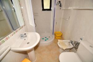 a white bathroom with a sink and a toilet at VIVENDA JOHANNA in Lagos