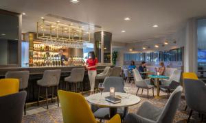 a restaurant with tables and chairs and a bar at Maldron Hotel South Mall Cork City in Cork
