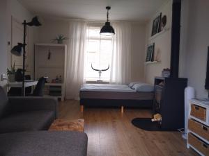 een woonkamer met een bed en een raam bij AwayHome Zwolle in Zwolle